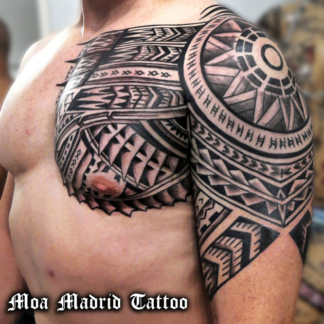 Tatuaje maorí en brazo y pectoral siguiendo las formas de la musculatura