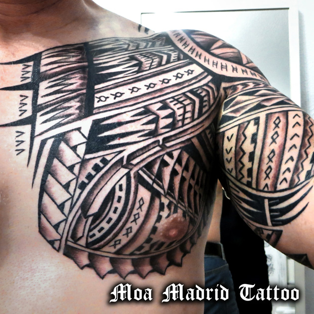 Tatuaje maorí en brazo y pectoral siguiendo las formas de la musculatura