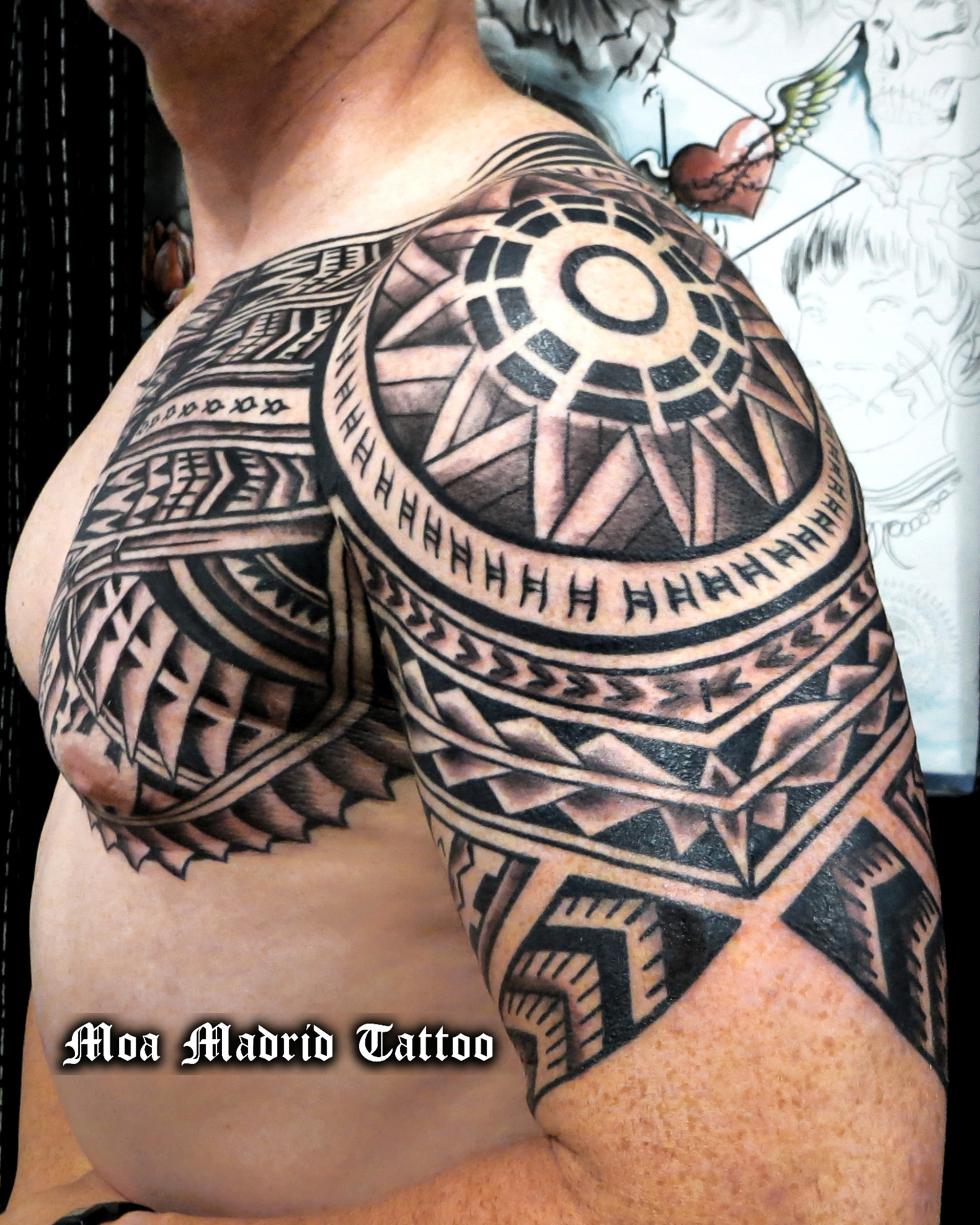 Tatuaje maorí adaptado a las formas del pectoral y el brazo