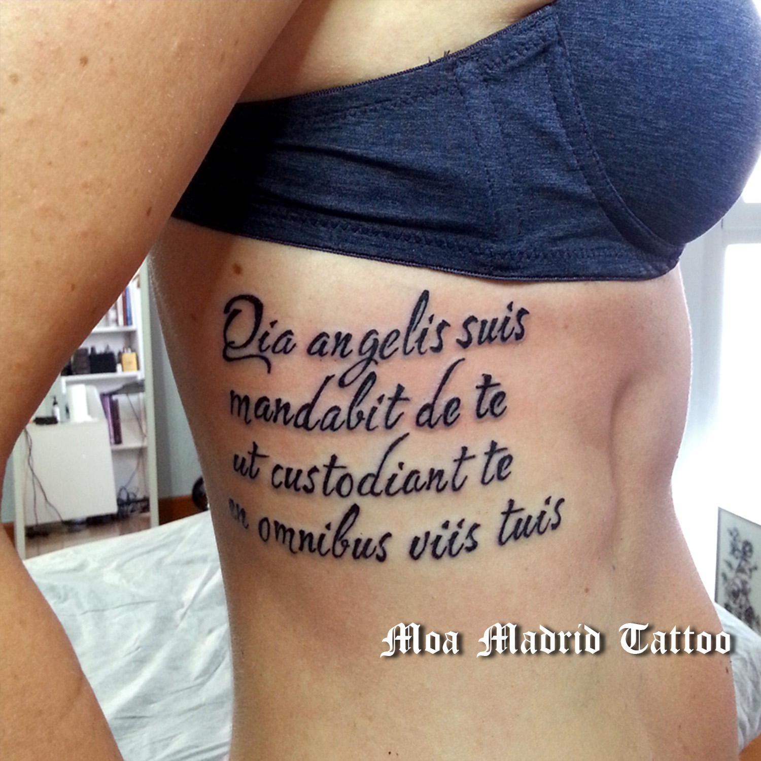Tatuaje de frases en latín, lettering tattoo, Salmos 91:11, en costado de mujer