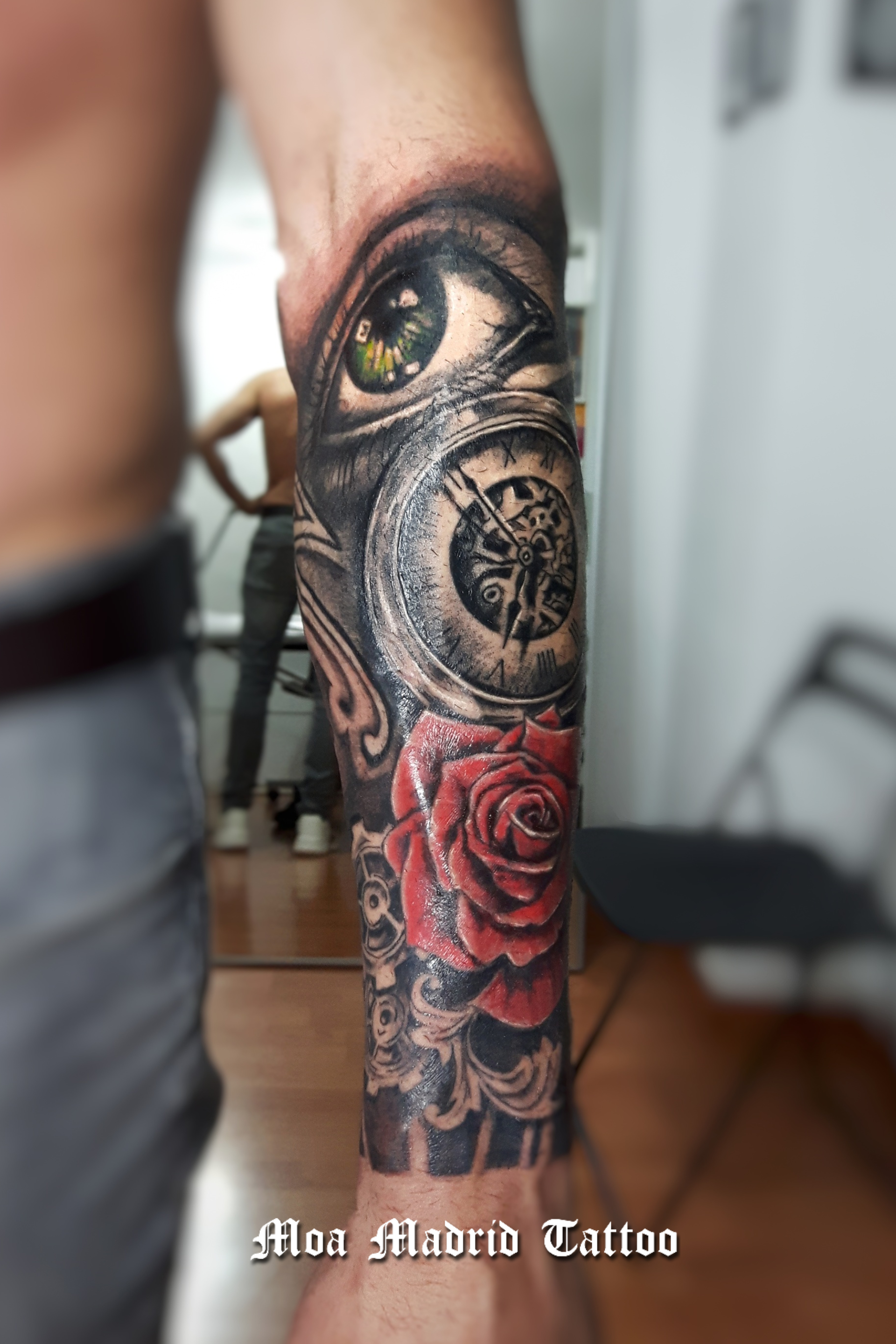 Un elegante tatuaje en realismo en blanco y negro y color, con un ojo, un reloj antiguo y una rosa