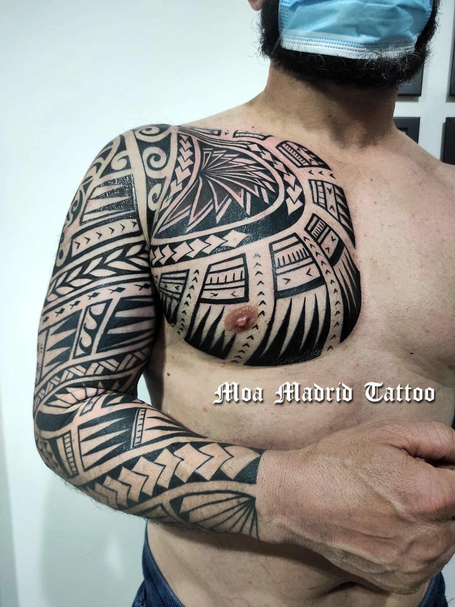 Tatuaje samoano adaptado con diseño adaptado a las formas de los músculos del brazo y el pectoral