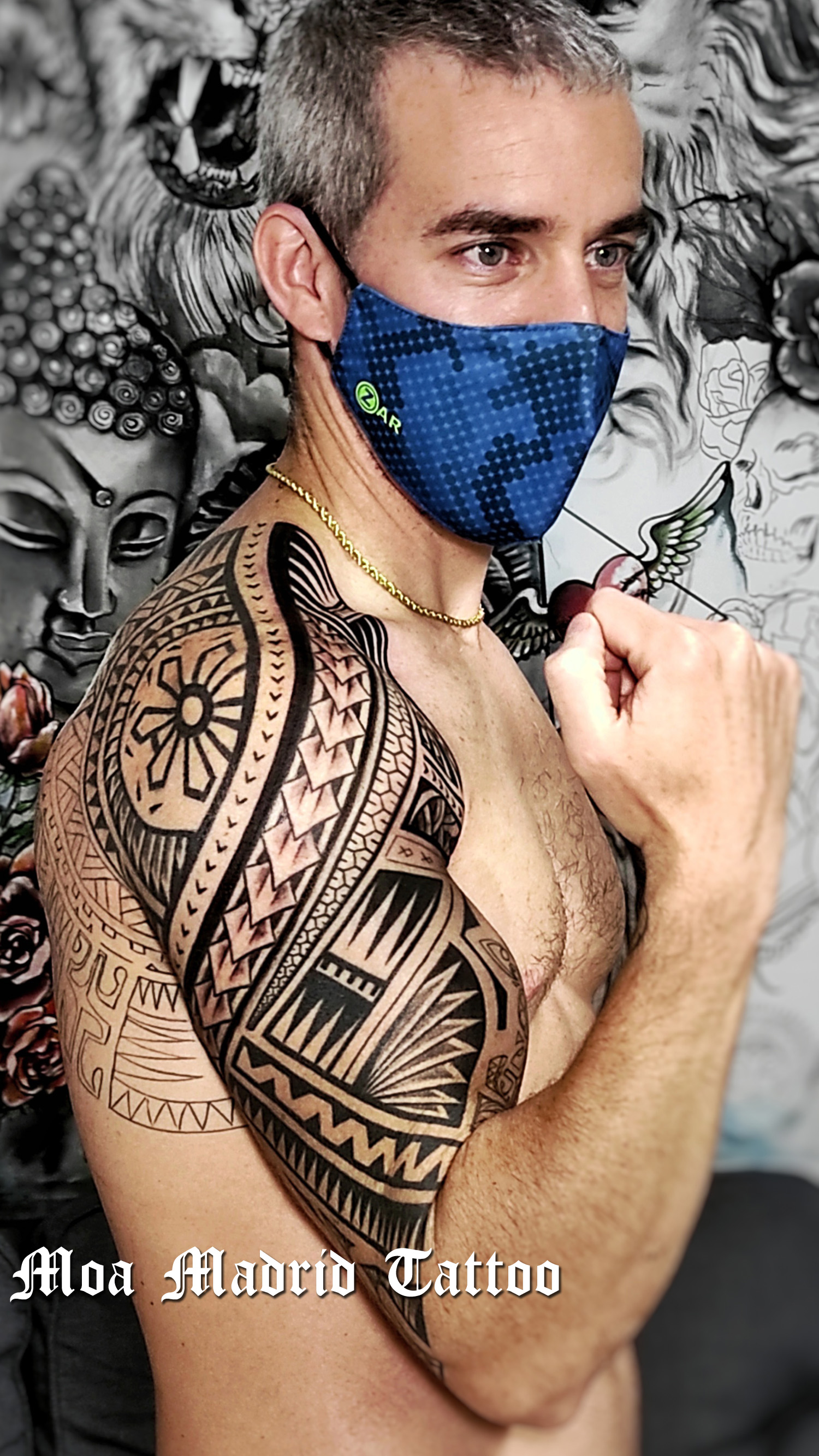 Tatuaje samoano en el brazo hecho en Madrid, y líneas de la parte del omóplato