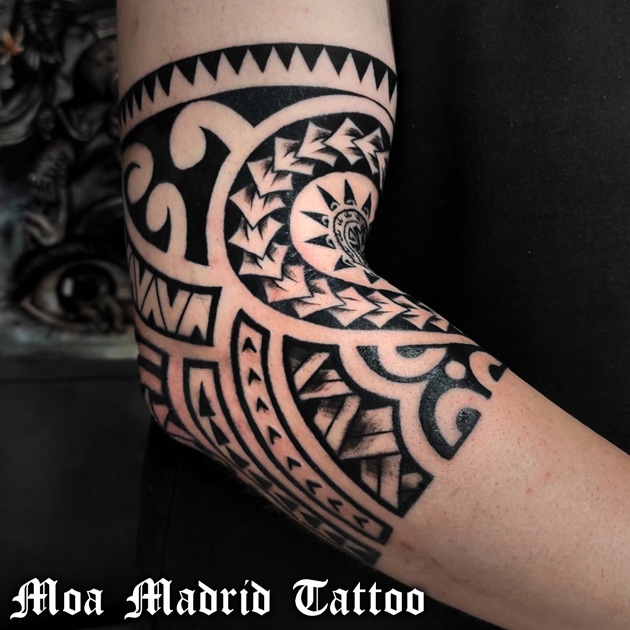 Tatuaje maorí con sol rodeando el codo