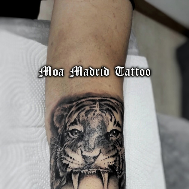 Realista tatuaje de retrato de mujer con tigre en el antebrazo