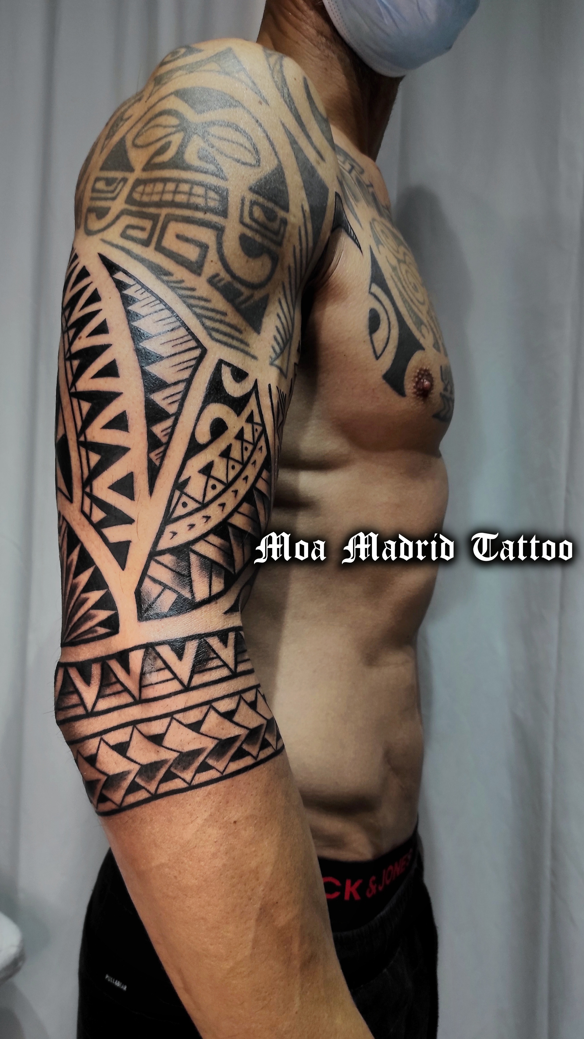 Tatuaje estilo samoano en el brazo de deltoides a codo