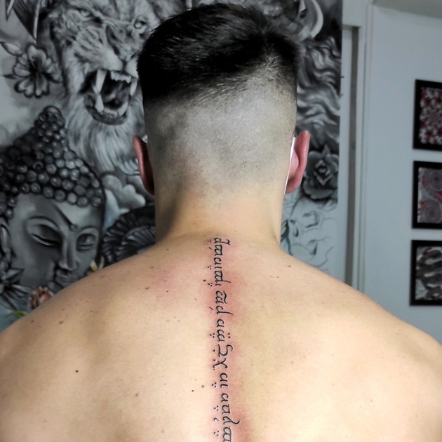 Tatuaje en élfico en columna espalda de hombre