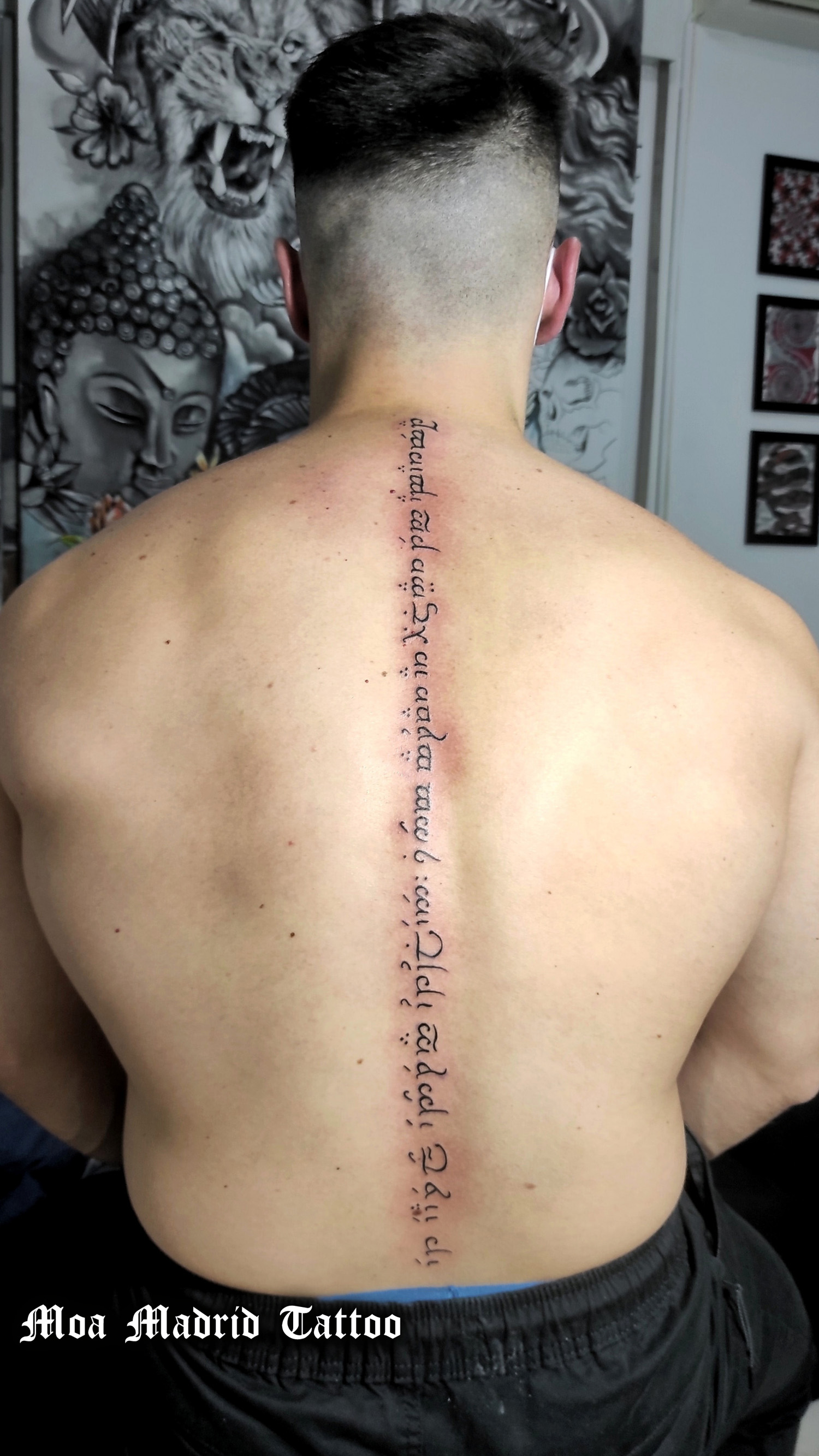 Tatuaje con texto escrito en élfico en espalda de hombre