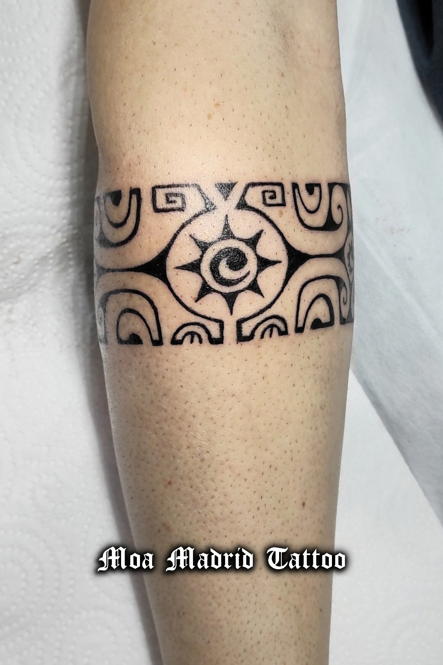 Tatuaje de brazalete polinesio con símbolos de tortuga, cuyo significado es tranquilidad; sol, cyto significado es fuerza; y koru, símbolo de superación de adversidades