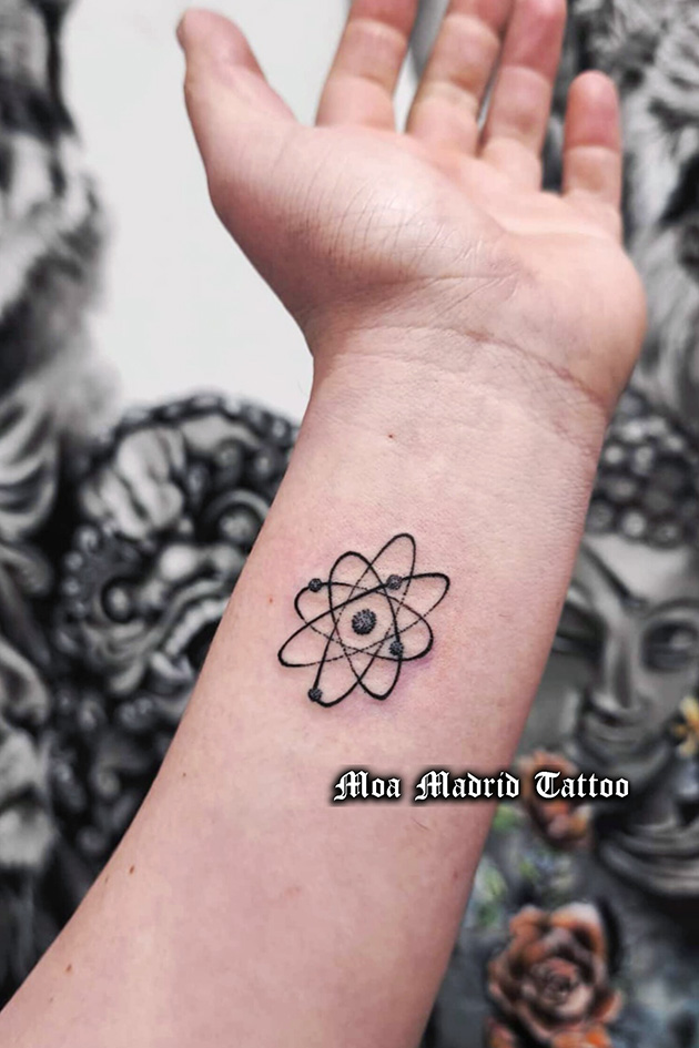 Tatuaje de átomo en la muñeca