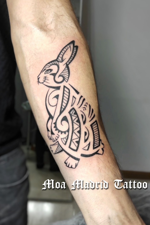 Tatuaje estilo maorí de conejo en el antebrazo elegido entre varios diseños
