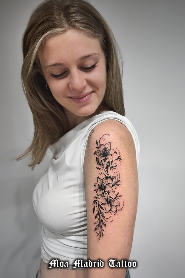 Elegante tatuaje de flores en brazo de mujer